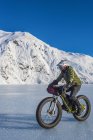 Homme chevauchant fatbike à travers le lac Portage gelé au milieu de l'hiver dans le centre-sud de l'Alaska, États-Unis d'Amérique — Photo de stock