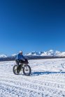 Hombre montando una fatbike en el Chulitna Bluff Trail en un día soleado de invierno. Centro-sur de Alaska, Estados Unidos de América - foto de stock