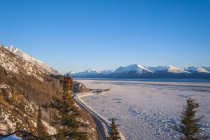 Vue panoramique de la route Seward en hiver avec la marée descendante et la glace en mouvement flottant au-delà de Beluga Point comme coucher de soleil, Alaska, États-Unis d'Amérique — Photo de stock