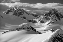 Скалистые монолиты и башни тянутся к небу сквозь тысячи футов ледникового льда на ледяном поле Джуно в Национальном лесу Тонгасс на Аляске; Аляска, Соединенные Штаты Америки — стоковое фото