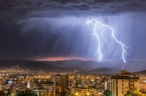 Ciel orageux et éclairs au-dessus d'une ville la nuit, Cochabamba, Bolivie — Photo de stock