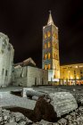 Roman ruins and the Tower of St Anastasia Cathedral at night; Zadar, Croatia — Stock Photo