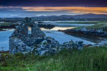 Ruinas de un edificio de piedra al atardecer en Mweenish Island, Wild Atlantic Way; Inishmore Island, County Galway, Irlanda - foto de stock