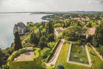 Landscaped grounds of Duino Castle and a view of the coastline of the Gulf of Trieste; Italy — Stock Photo