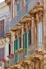 Fachada de um edifício residencial com persianas e varandas; Siracusa, Sicília, Ortigia, Itália — Fotografia de Stock