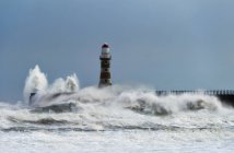 Roker Lighthouse and waves from the River Ware crashing onto the pier; Sunderland, Tyne and Wear, England — Stock Photo