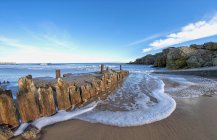 Espuma e surfe em uma praia ao longo da costa atlântica; South Shields, Tyne and Wear, Inglaterra — Fotografia de Stock