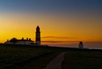 Souter Lighthouse ao pôr-do-sol com laranja brilhante e pôr-do-sol dourado; South Shields, Tyne and Wear, Inglaterra — Fotografia de Stock