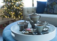 Chá servido em uma bandeja com biscoitos e uma árvore de Natal no fundo no Natal; Surrey, British Columbia, Canadá — Fotografia de Stock