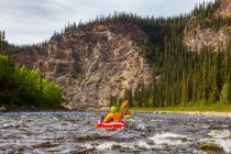 Two women packrafters negotiating a tributary of the Charley River in summertime, Yukon Charley Rivers National Preserve; Alaska, United States of America — Stock Photo