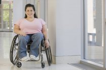 Женщина со Спиной Бифидой сидит в инвалидном кресле и улыбается — стоковое фото