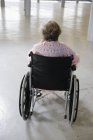 Visão traseira de uma mulher idosa sentada na cadeira de rodas - Estágio — Fotografia de Stock