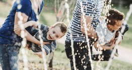 Семья с маленькими детьми, играющая в спрей-парке; Эдмонтон, Альберта, Канада — стоковое фото