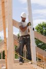 Плотник держит стропила на строительной площадке — стоковое фото