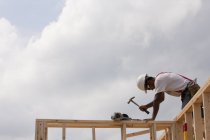 Niedrige Winkelaufnahme eines Zimmermanns, der auf Wandrahmen hämmert — Stockfoto