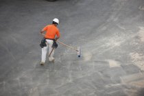 Carpenter sweeping up after building — Stock Photo