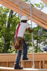 Carpenter climbing a ladder at building construction site — Stock Photo