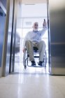 Professor universitário com Distrofia Muscular em uma cadeira de rodas entrando em um elevador — Fotografia de Stock