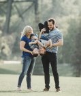 Una familia con niños pequeños jugando en un parque; Edmonton, Alberta, Canadá - foto de stock