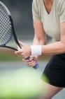 Вид на середню секцію літньої жінки, яка грає в теніс — стокове фото