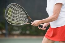 Средняя часть изображения пожилой женщины, играющей в теннис — стоковое фото