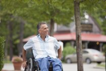 Man with spinal cord injury in a wheelchair out shopping — Stock Photo
