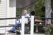 Uomo con lesione del midollo spinale su una sedia a rotelle in cima a una rampa accessibile — Foto stock