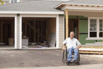 Homme blessé à la moelle épinière en fauteuil roulant dans sa nouvelle maison accessible en construction — Photo de stock