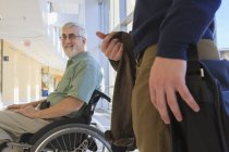 Professor com Distrofia Muscular em um corredor universitário com um estudante — Fotografia de Stock