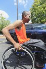 Человек, у которого был менингит позвоночника в инвалидной коляске, вот-вот сядет в автомобиль — стоковое фото