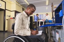 Étudiant en fauteuil roulant étudiant le système de contrôle électronique de four dans la salle de classe CVC — Photo de stock