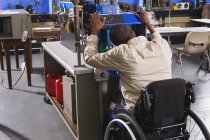 Студент в інвалідному візку вивчає систему електронного управління печі в класі HVAC — стокове фото