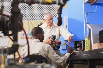 Istruttore che dimostra il collettore di ricarica del condizionatore d'aria con misuratori in classe HVAC studente in sedia a rotelle — Foto stock