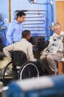 Instructor using demo board to explain HVAC control system operation one student in wheelchair — Stock Photo