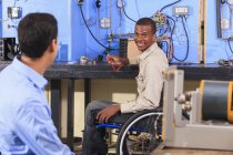 Étudiant en fauteuil roulant mise en place expérience CVC parler à un autre étudiant — Photo de stock