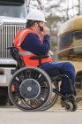 Construction engineer with spinal cord injury talking on radio at home construction site — Stock Photo