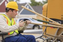 Supervisor de construção com lesão medular contando ferramentas de trabalho no canteiro de obras — Fotografia de Stock