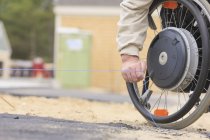 Construction supervisor with Spinal Cord Injury pulling chalkline at edge of pavement — Stock Photo