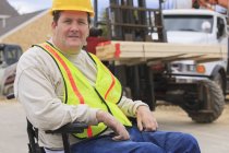 Construction supervisor with Spinal Cord Injury with forklift moving studs — Stock Photo
