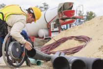 Construction supervisor with Spinal Cord Injury inspecting drainage pipes — Stock Photo