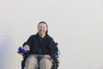 Uomo con lesione del midollo spinale e braccio con danno nervoso in sedia a rotelle motorizzata — Foto stock