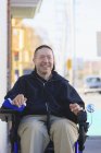 Mann mit Querschnittslähmung und Arm mit Nervenschäden im motorisierten Rollstuhl überquert öffentliche Straße — Stockfoto
