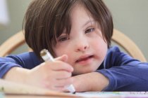 Criança com Síndrome de Down usando marcadores de coloração — Fotografia de Stock