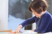 Маленька дівчинка з синдромом Дауна грає в навчальну гру. — стокове фото