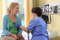 Медсестра з Церебралом Пальсі на тростинах перевіряє серце пацієнта. — стокове фото