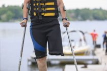 Mujer con una pierna a punto de ir a esquiar en el lago - foto de stock