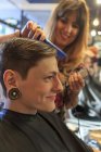 Homme à la mode avec une lésion de la moelle épinière dans un salon de coiffure se faire couper les cheveux — Photo de stock
