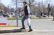Слепой молодой человек гуляет по окрестностям после покупок — стоковое фото