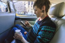 Trendsetter mit Querschnittslähmung im Rollstuhl im Taxi beim Lesen seiner SMS — Stockfoto