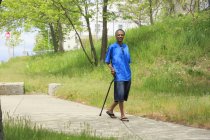 Homme avec traumatisme crânien faisant une promenade avec sa canne — Photo de stock